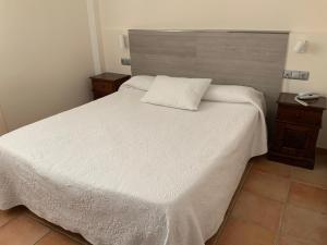a bedroom with a white bed with a wooden headboard at Santuario San José in San José