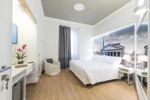 a white bedroom with a bed and a desk at Charming Roma in Rome