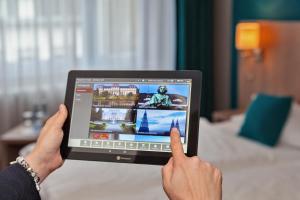 a person holding up a tablet with their hands at President Hotel in Bonn