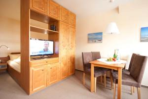 a room with a table and a television in a room at Juist Ferienwohnung 304 Strandburg in Juist