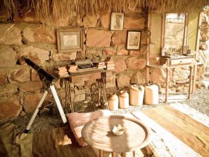 een kamer met een tafel en een stenen muur bij Deep south Eco-lodge in Marsa Alam