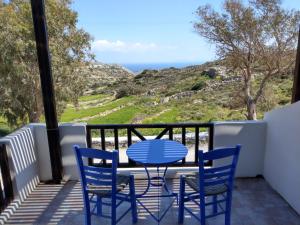 een tafel en stoelen op een balkon met uitzicht op de oceaan bij Chora Place in Síkinos