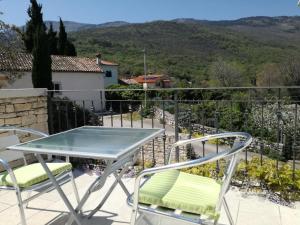 a glass table and chairs on a balcony with a view at Apartments Villa Ina in Brseč