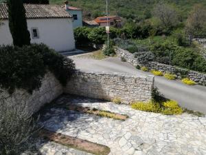 a stone retaining wall next to a road at Apartments Villa Ina in Brseč
