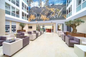 a lobby of a building with couches and trees at Hotel Dražica - Hotel Resort Dražica in Krk