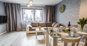 ein Wohnzimmer mit einem Sofa und einem Tisch in der Unterkunft Apartamenty hoteLOVE z sauną przy Strumieniu in Karpacz