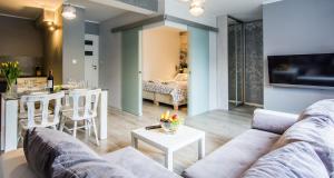 ein Wohnzimmer mit einem Sofa und einem Tisch in der Unterkunft Apartamenty hoteLOVE z sauną przy Strumieniu in Karpacz