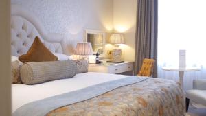 1 dormitorio con cama, silla y espejo en Imperial Hotel Cork City en Cork