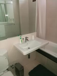 a bathroom with a sink and a toilet and a mirror at 45 Lighthouse Mall Apartment in Durban
