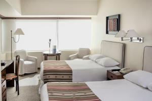 Tempat tidur dalam kamar di Almacruz Hotel y Centro de Convenciones (Ex Galerías)