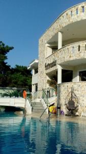 una piscina di fronte a un edificio di Hatzoudis Luxury Suites a Chrisi Ammoudia