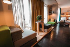 un salon avec un canapé et une chambre avec un lit dans l'établissement Le Citizen Hotel, à Paris