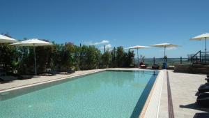 una piscina con sillas y sombrillas en Hotel Leone, en Montelparo