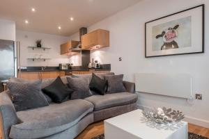 a living room with a couch and a kitchen at The Chambers, Riverside West in Leeds