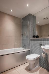 La salle de bains est pourvue de toilettes, d'une baignoire et d'un lavabo. dans l'établissement The Chambers, Riverside West, à Leeds