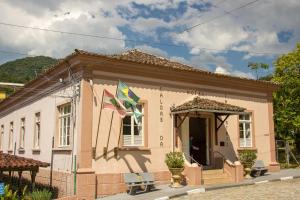 a small pink house with two flags in front of it at Hotel Caldas da Imperatriz in Santo Amaro da Imperatriz