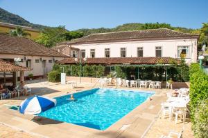 a swimming pool in a yard with a house at Hotel Caldas da Imperatriz in Santo Amaro da Imperatriz