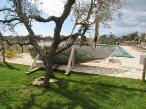 a boat in a tree next to a pool at Agriturismo Sweet Cottage in Marina di Grosseto