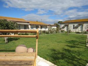 a yard with a house and a yard with grass at Agriturismo Sweet Cottage in Marina di Grosseto