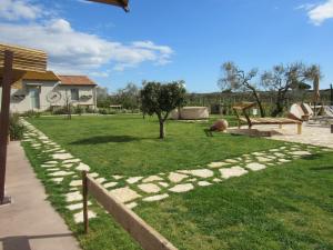a garden with a rock pathway and a park at Agriturismo Sweet Cottage in Marina di Grosseto