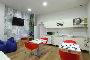 kuchnia i jadalnia z czerwonymi krzesłami i stołem w obiekcie MCC Hostel w mieście Celje