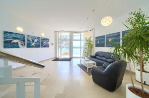 a living room with a blue couch and some plants at Villa Tamaris - Hotel Resort Dražica in Krk