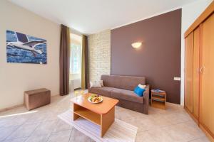 ein Wohnzimmer mit einem Sofa und einem Tisch in der Unterkunft Villa Tamaris - Hotel Resort Dražica in Krk
