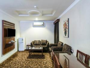 sala de estar con 2 sofás y TV en Mocador Aparthotel - Al Nuzha Branch, en Riad