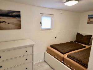 a bedroom with a bed and a dresser and a window at Haus auf der alten Düne 2 in Prerow
