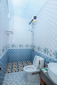 a blue tiled bathroom with a toilet and a shower at Tam Coc Ngo Đong Homestay in Ninh Binh