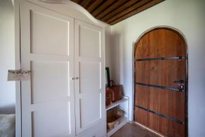 una puerta abierta en una habitación con puerta de madera en VINIFERA VINEYARDS HOTEL, en Selçuk