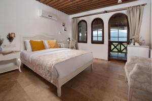 een slaapkamer met een wit bed met oranje kussens bij VINIFERA VINEYARDS HOTEL in Selcuk