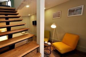 a living room with a yellow chair and stairs at Modern Apartments in Tbilisi City