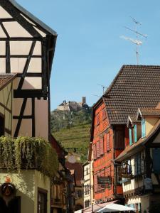 a city street with buildings and a hill in the background at À La Cour de Ribeauvillé avec garage in Ribeauvillé