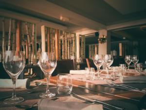 une table avec des verres à vin dessus dans l'établissement Appart'Hôtel LIDO au bord de l'eau, à Gérardmer