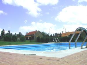 una gran piscina de agua azul y un edificio en Camping Fragadeume en Monfero