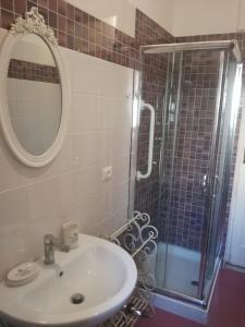 une salle de bain avec un lavabo et une douche avec un miroir dans l'établissement Live and Love, à Naples