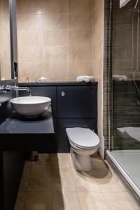 La salle de bains est pourvue de toilettes, d'un lavabo et d'une baignoire. dans l'établissement Fir Trees Hotel, à Strabane