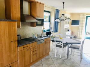 a kitchen with a sink and a table with chairs at "Backbord" by Ferienhaus Strandgut in Born +14 photos