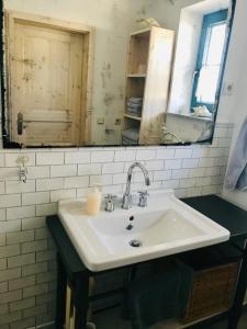 a bathroom with a sink and a mirror at "Backbord" by Ferienhaus Strandgut in Born