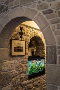 a stone wall with a fish tank in a niche at Cretan Villa in Ierapetra