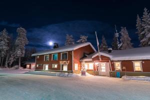 a house in the snow at night at Kuerkievari KuerHostel in Äkäslompolo