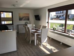 - une salle à manger avec une table, des chaises et des fenêtres dans l'établissement Freizeitcenter Bad Sachsa, à Bad Sachsa