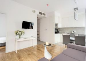 a white living room with a couch and a table at Apartamenty Vola Residence in Warsaw