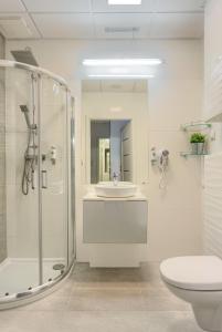 une salle de bain avec un lavabo, une douche et des toilettes dans l'établissement Apartamenty Vola Residence, à Varsovie 32 autres photos