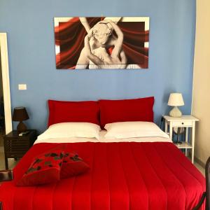 a bedroom with a red bed with a painting on the wall at Il Da Vinci casa vacanze in Giovinazzo