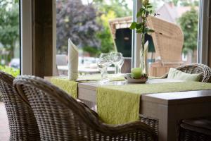 a table with chairs and wine glasses on a patio at Paulsen's Landhotel und Restaurant in Bohmstedt
