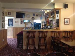 a bar in a restaurant with bar stools in a room at The Safe Harbour Hotel in Fowey