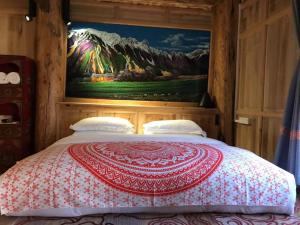 a bedroom with a bed with a painting on the wall at The blue mountains on the moon in Shangri-La