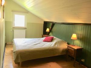 een slaapkamer met een bed, 2 lampen en een raam bij Gîte la Semois à Mouzaive Vresse sur Semois in Vresse-sur-Semois